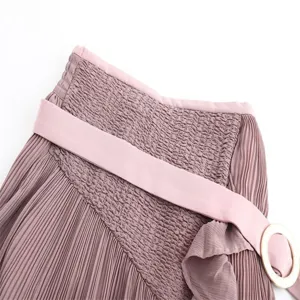 Women's high waist pleated skirt detail featuring smocked waist and matching belt.