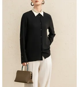 Elegant women's black long-sleeve shirt with contrast white collar, detailed close-up shot.