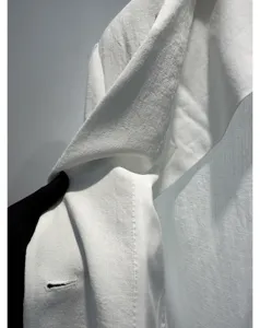 Detail van premium witte dames zomercollectie colbert, ademende stof, elegant en modern design.