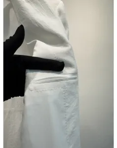 Detailopname van de witte damesblazertas, met fijne stiksels en hoogwaardige stofkwaliteit.