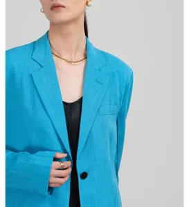 Blauwe blazer detailfoto met lange mouwen, reverskraag en ademende, lichtgewicht stof.