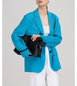 Gedetailleerd overzicht van een stijlvolle helderblauwe blazer gedragen met een zwarte tas.