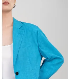 Detailopname van een levendige blauwe damesblazer met klassieke revers en een enkel knoopje.