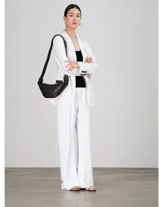 Gedetailleerd overzicht van het elegante witte zomerblazerpak met fijne textuur en pasvorm.