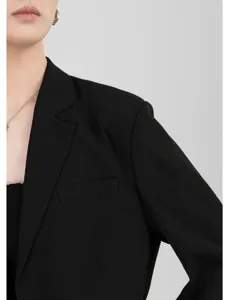 Close-up detail van zwarte damesblazer, revers en schouder, ademende stof voor de zomer.