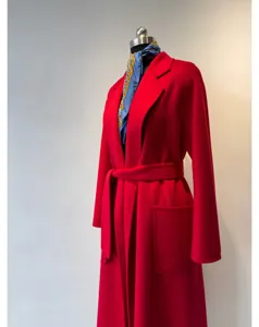 Detail view of a luxury red cashmere wrap coat with a matching belt and deep pockets.