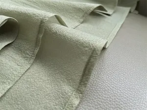 Detailed view of light green textured acetate organza fabric showing delicate sheen and drape.