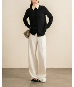 Detail view of the elegant contrast color collar long sleeve blouse and white pants.