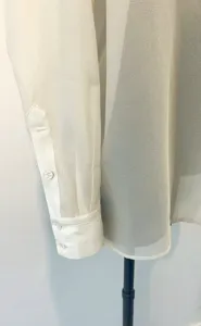 Close-up detail of sheer organza women long sleeve shirt sleeve and button texture.