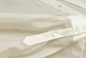 Detailed close up of a sheer acetate organza shirt showcasing exquisite cuffs and buttons.
