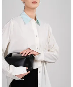 Elegant women long sleeve contrast collar button down shirt paired with black trousers and bag.
