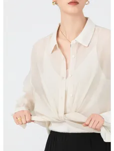 Close-up of translucent acetate organza shirt hem detail, lightweight sheer fabric texture.