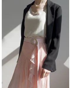 Detail shot of pink pleated skirt with black blazer, elegant daily wear for women.