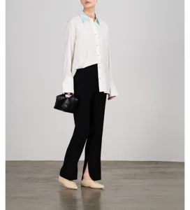 Detailed view of the elegant white long-sleeve blouse featuring a contrast collar and chic cuffs.