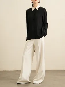 Women's elegant contrast color long sleeve shirt and white wide leg trousers set.