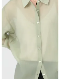 Close-up view of a light green translucent acetate organza shirt detail, breathable and elegant.
