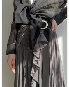 Japanese style high waist pleated midi skirt with black sheer blouse detail view.