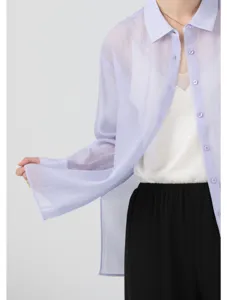 Detail shot of sheer translucent organza shirt woman, lightweight summer sunscreen cardigan.