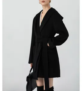 Detailed view of women's black hooded wool coat, featuring a tie belt and elegant cut.