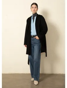 Detailed shot of casual black hooded coat outfit with turtleneck and blue shirt styling.