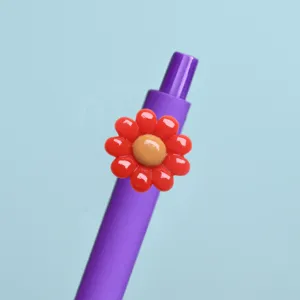 Nahaufnahme eines lila Tintenrollers mit einer niedlichen roten Harzblume als Detailverzierung.