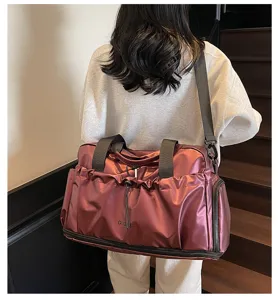 Vista dettagliata della borsa da viaggio rosso vino con scomparto scarpe e tracolla.