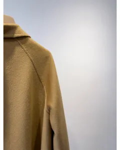 Close-up detail of the premium camel cashmere wool blend coat shoulder and collar line.