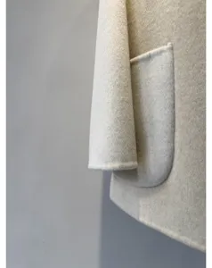 Detail de manteau en laine cachemire de qualite avec tissu doux et poche pour femmes.