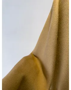 Luxury cashmere coat fabric detail shot, camel color double-sided wool material, soft texture.