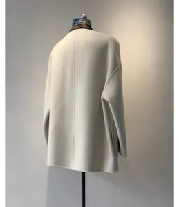 Vue de dos détaillée d'un manteau chic en cachemire et laine beige avec une belle écharpe.