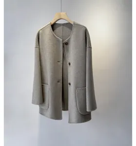 Détail du manteau en laine et cachemire gris, design minimaliste sans col avec poches.