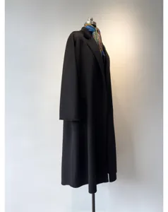 Close-up detail of luxury black cashmere wrap coat featuring elegant lapel and soft fabric.