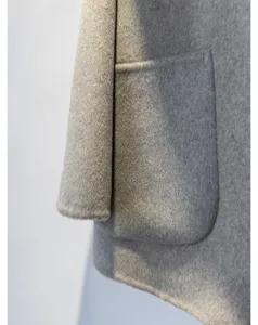 Vue detaillee du manteau en laine et cachemire gris, mettant en valeur poche et manche.