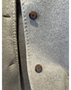 Gros plan détaillé de la texture du tissu en cachemire, des finitions et des boutons.