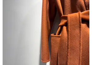 Detailed view of women luxurious cashmere wool wrap coat pocket and belt texture winter.