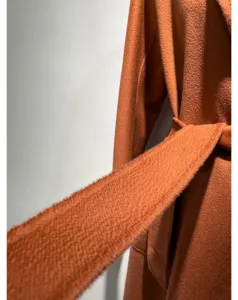 Cashmere coat fabric detail, soft texture wool belt close up, winter outerwear close-up.