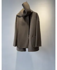 Gros plan manteau femme en laine et cachemire avec écharpe intégrée, beau tombé fin.