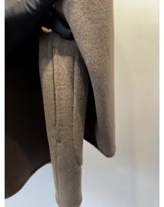 Gros plan détaillé de la texture luxueuse et des belles finitions de ce manteau en laine.