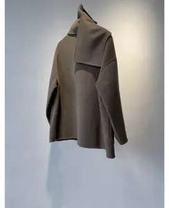 Gros plan du manteau en laine cachemire automne hiver avec design d'écharpe intégré élégant.