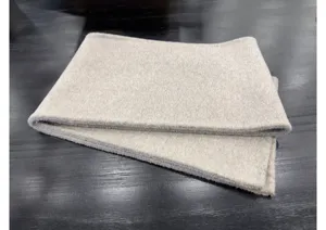 Gros plan détaillé d'une douce écharpe en laine cachemire beige élégante et texturée.