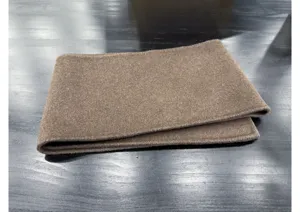 Détail de tissu en laine cachemire marron, texture douce et toucher luxueux pour vêtements.