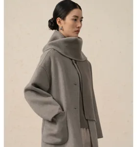 Vue détaillée d'un manteau femme en cachemire gris avec col écharpe et grandes poches.