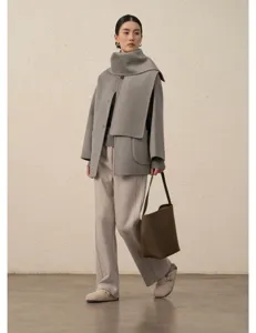 Vue détail manteau femme laine cachemire avec écharpe, style hiver minimaliste élégant.