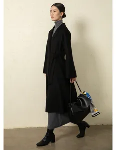 Black cashmere-blend wrap coat detail shot, featuring classic lapels and matching waist belt.
