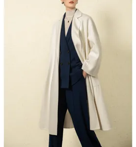 Detailed close-up showcasing women's white cashmere coat and navy blue suit vest set.