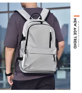 Vista detallada de la mochila gris casual usada por el modelo con práctico bolsillo frontal.