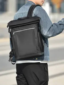 Close-up detail shot of a black minimalist business backpack worn outdoors by a model.