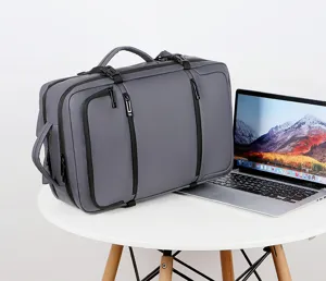 Zaino da viaggio aziendale grigio mostrato su tavolo bianco con contesto laptop.