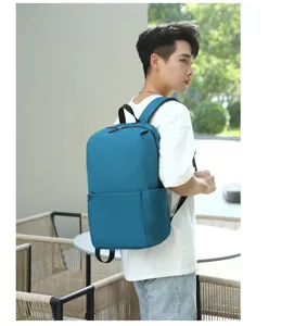 Detailed view of casual travel backpack worn by model, showing durable fabric and front pocket.