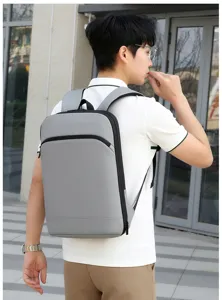 Vista detallada de la mochila elegante gris para portátil llevada por modelo al aire libre, diseño.